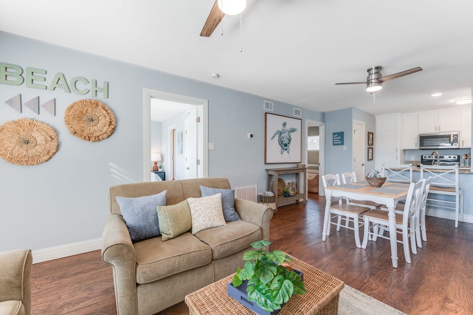 Relax in your coastal-themed living space where soft blues meet warm wood floors and natural textures create the perfect beach getaway atmosphere.