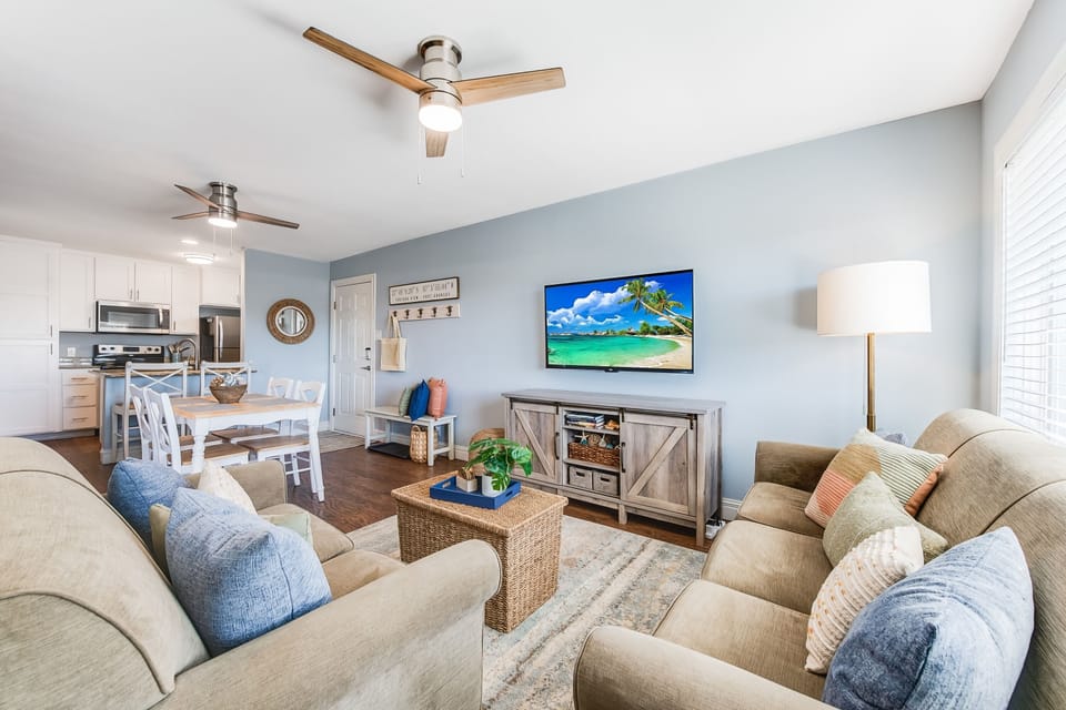 Unwind in your bright, coastal-inspired living space with plush seating, tropical TV views, and an open kitchen perfect for vacation meals.