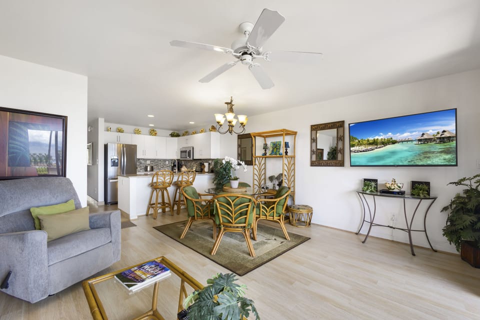 Relax in your open-concept living and dining area, beautifully designed with natural light, tropical accents, and a ceiling fan keeping things cool and comfortable.