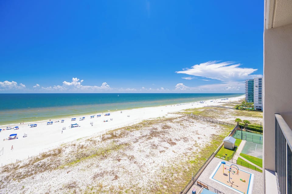 Warm sunlight brightens your balcony as you enjoy the wide stretch of soft beach and gentle coast breeze