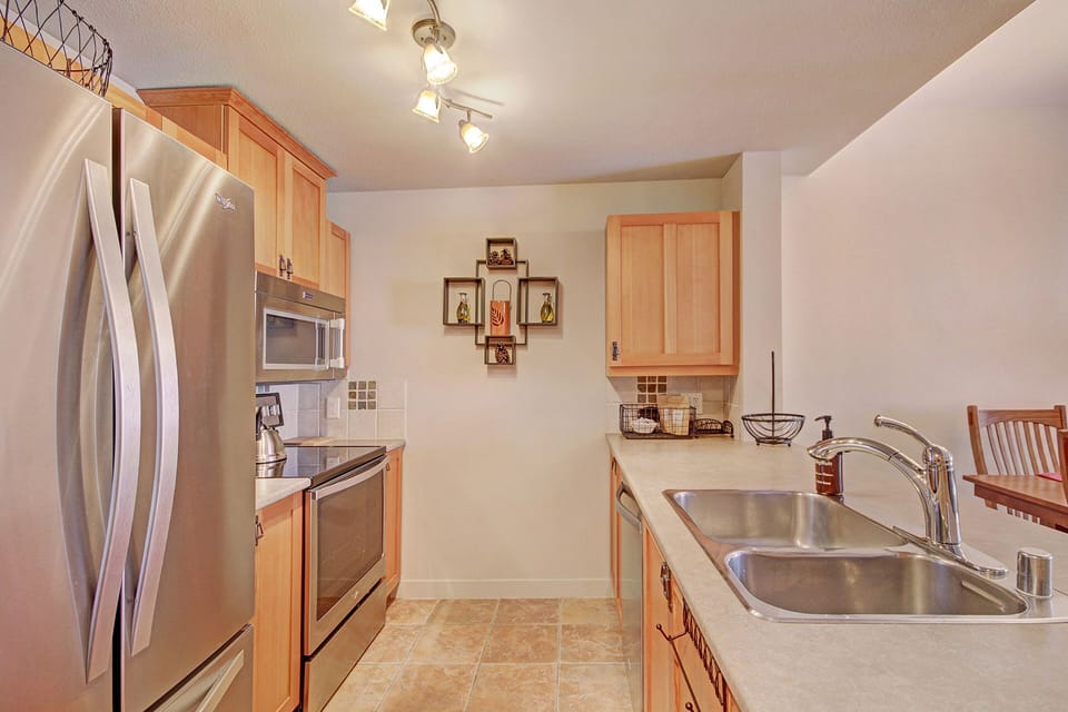 Kitchen area features stainless steel appliances.