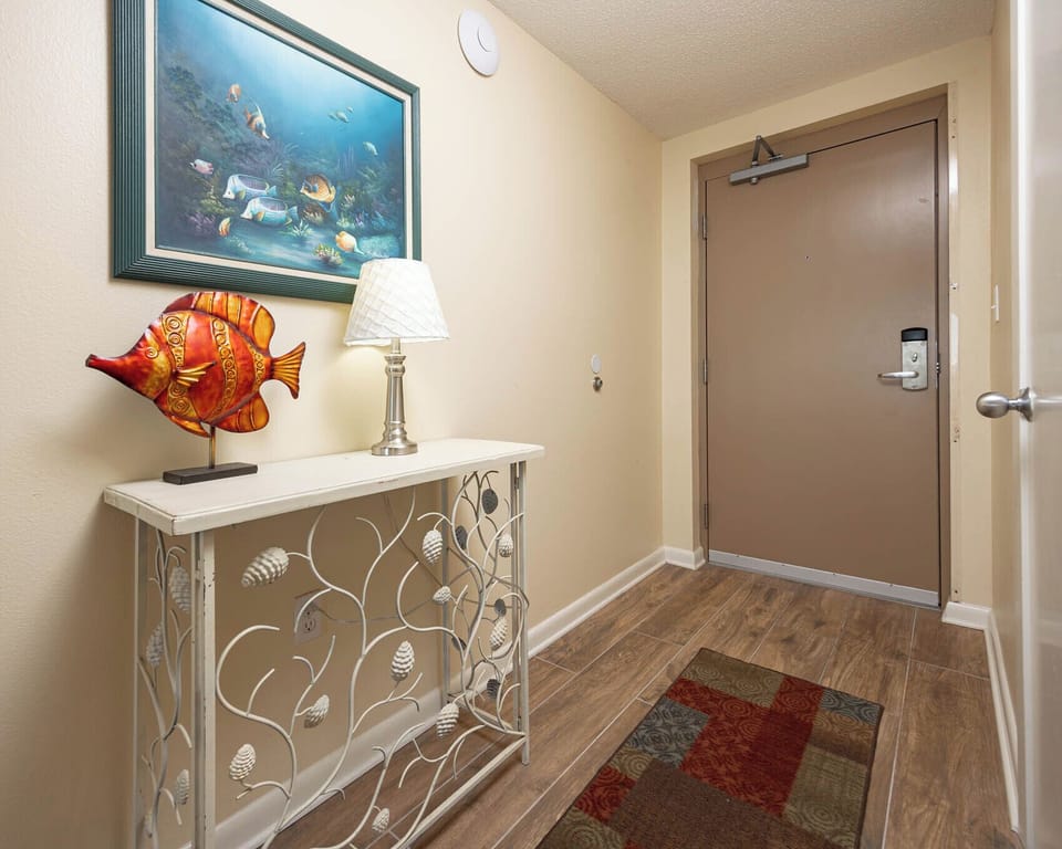 Step into a welcoming entryway featuring a decorative fish sculpture, stylish lamp, and a charming console table