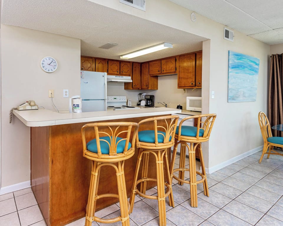 This inviting kitchen features wooden cabinetry, a breakfast bar with stylish seating, and a cozy dining area
