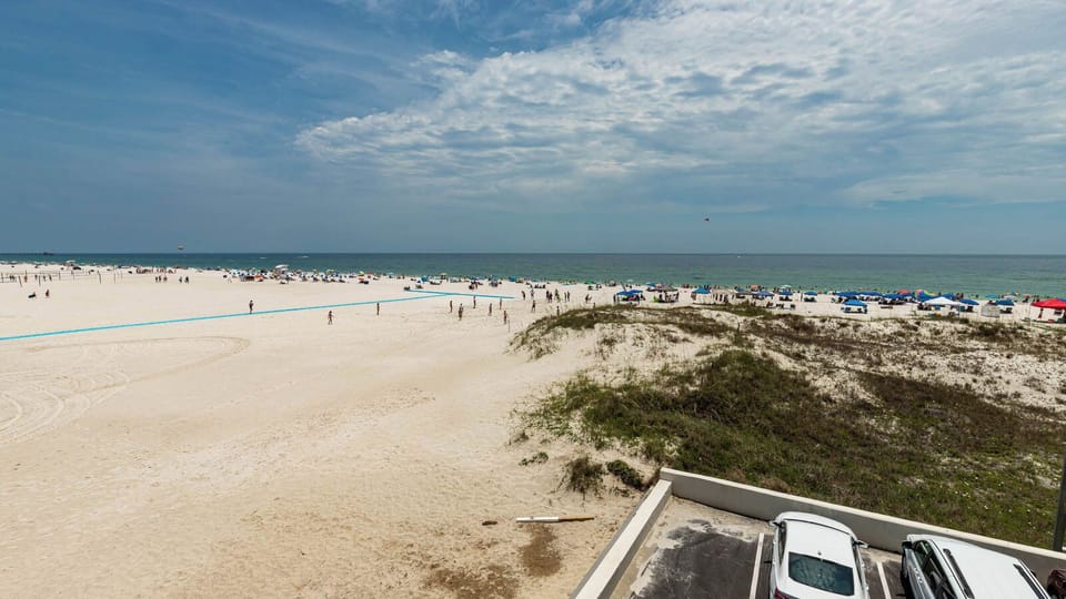 Experience a stunning beachfront view with vibrant umbrellas and sunbathers from this inviting space