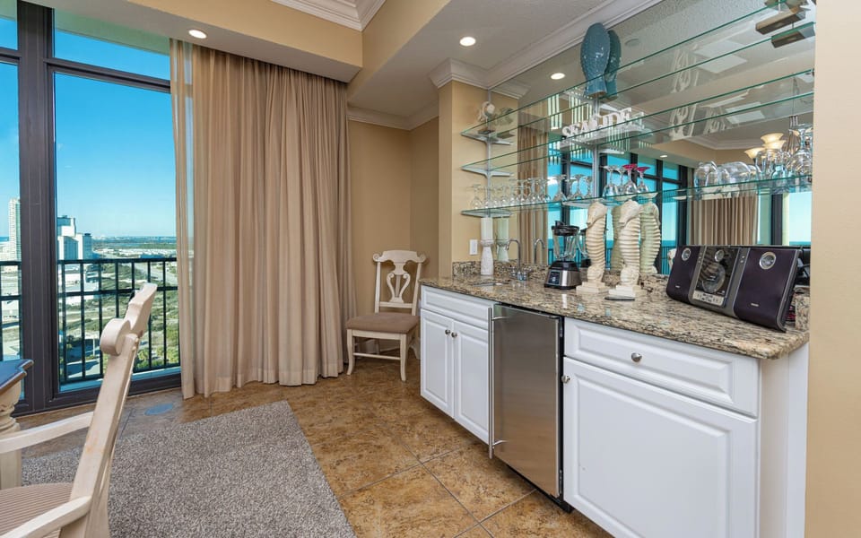 Grab a chilled drink or create a cocktail at this sleek wet bar with an elegant glassware display