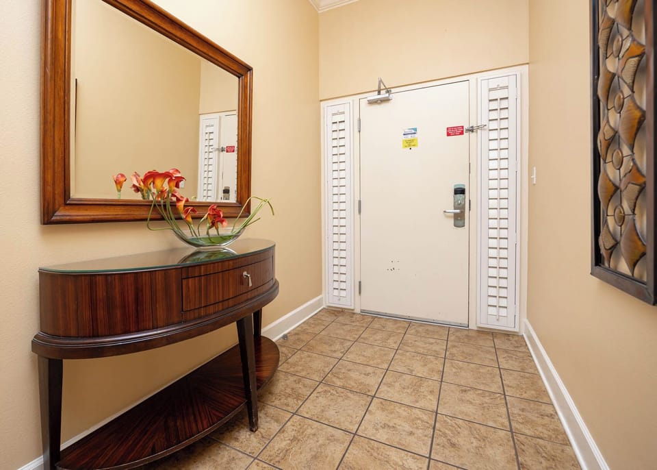 Step inside and admire the welcoming entryway, where a stylish table and colorful blooms invite you to unwind