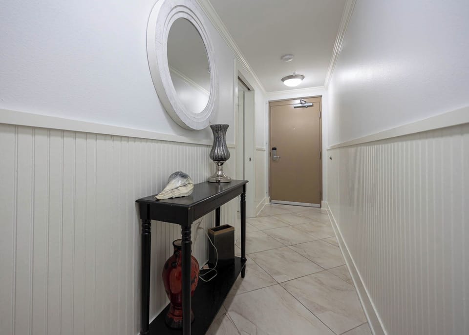 Step into a welcoming hallway featuring tasteful decor, a stylish console table, and a mirror that brightens the space