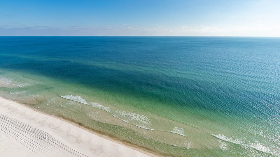 Gaze at the tranquil water and soft shoreline, perfect for peaceful strolls and enjoying nature's beauty