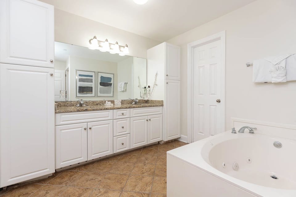 Refresh in the master bath after a day at the beach with a soothing jetted tub and relaxing walk-in shower