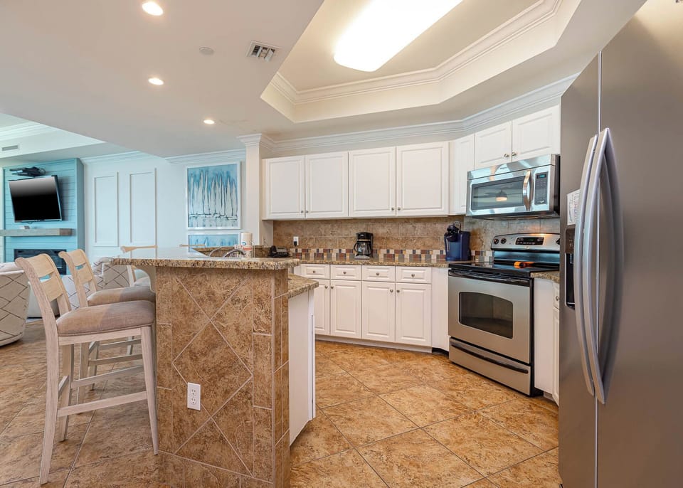 Prepare meals in this kitchen with elegant cabinetry, stainless appliances, and stylish backsplash