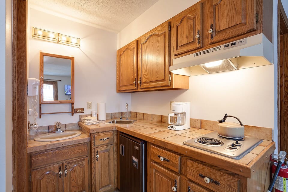 Your well-equipped kitchenette features warm wood cabinets, full appliances, and everything needed to prepare meals during your stay.