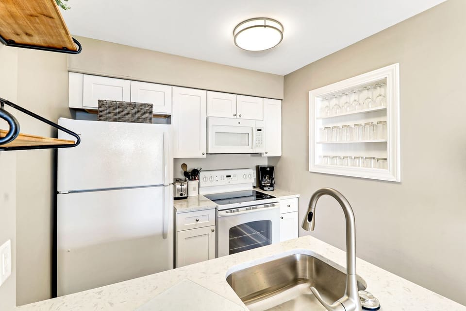 Ocean Dunes Villa 312 - Kitchen - The kitchen has a glass top stove and built-in wall shelves for extra cabinet space.