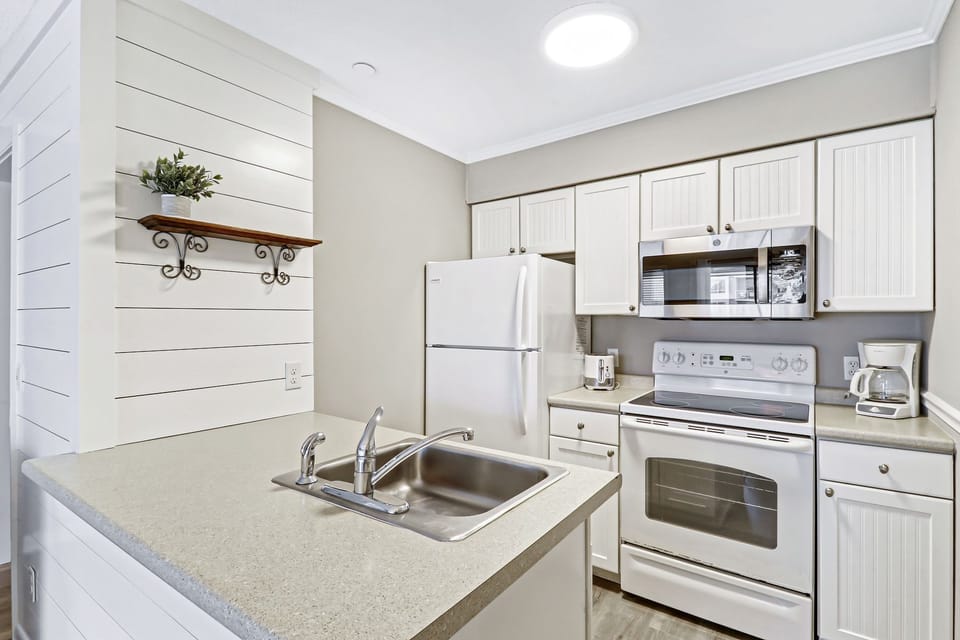 Kitchen - Love the shiplap accent wall in this bright and newly painted fully equipped kitchen.