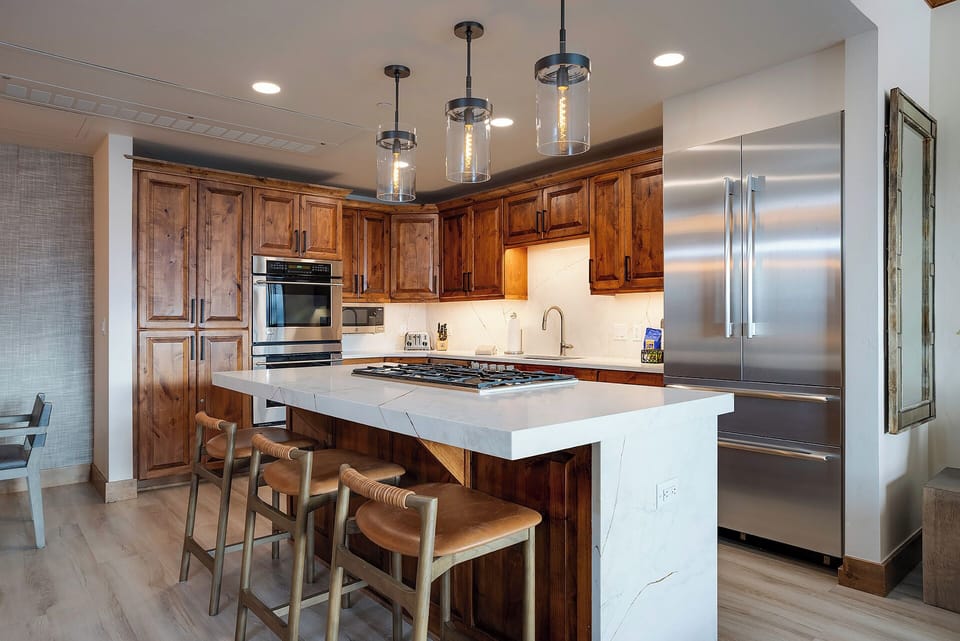 Picture yourself preparing gourmet meals in this beautifully appointed kitchen, featuring rich wood cabinetry, gleaming stainless steel appliances, and a spacious island perfect for gathering with loved ones.