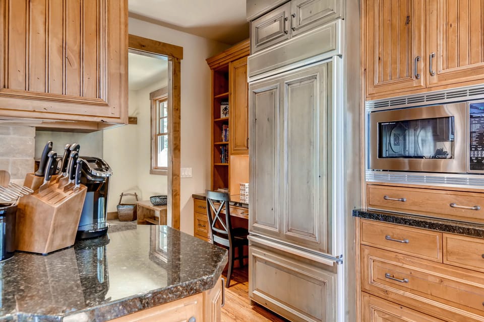 Fully equipped kitchen with French door wood paneled refrigerator and study/work nook in the entryway