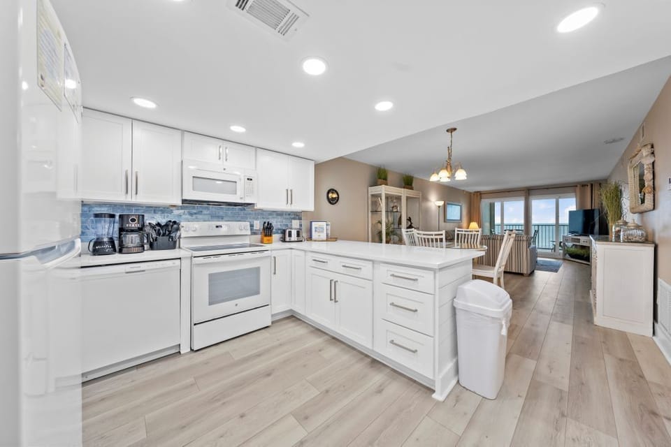 Cook your favorite meals in this bright, fully-equipped kitchen with modern appliances and stunning ocean views beyond.
