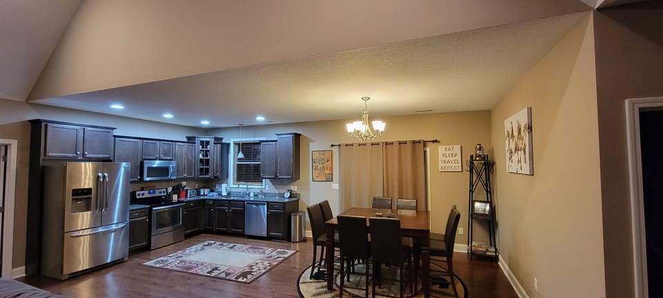stovetop, refrigerator, oven,microwave, dining table,kitchen visible, dishwasher