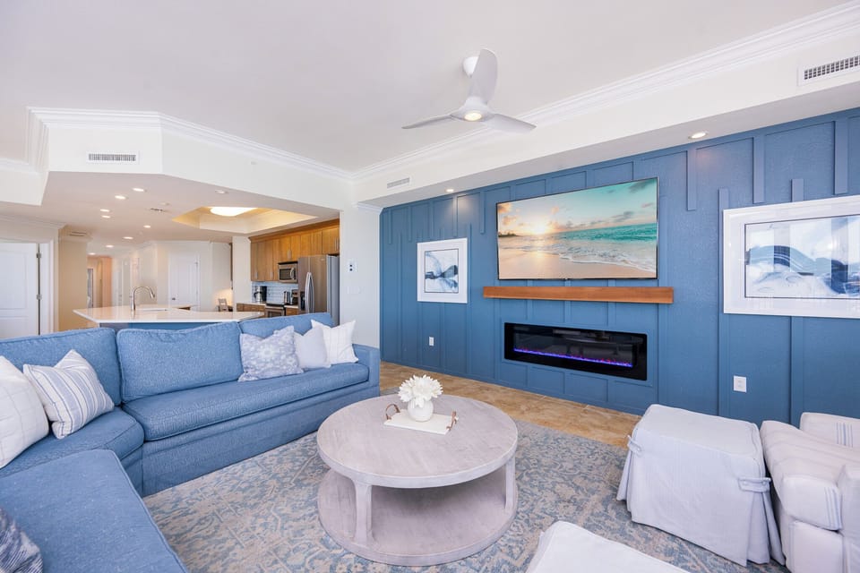 Gather in the inviting living area, where a cozy fireplace and the vibrant design create a warm retreat after a beach day