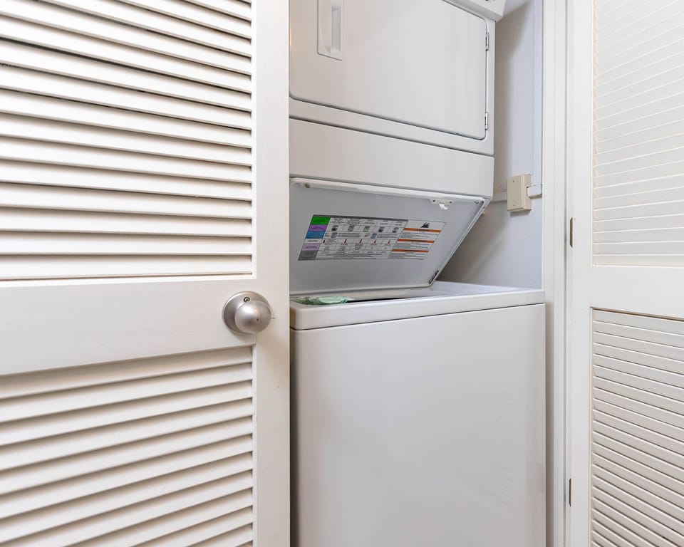 This laundry area features a stacked washer and dryer behind louvered doors, adding convenience to your stay