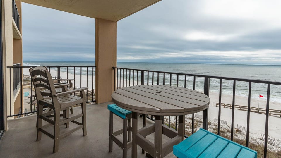 Relax on this fifth floor balcony with comfortable seating and enjoy the breathtaking beach view from this inviting space