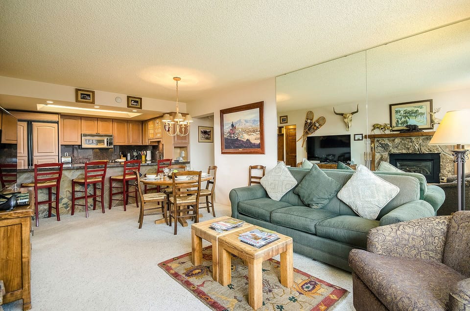 Relax in your spacious living room with cozy seating, warm fireplace, and open kitchen perfect for preparing meals together.