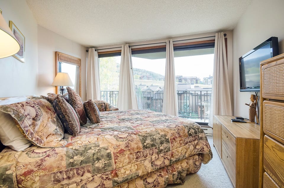Wake up to stunning mountain views from your cozy bedroom, where warm natural light fills the space through large windows.