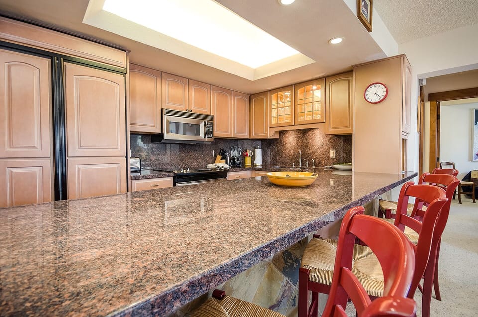 Cook together in this spacious kitchen featuring granite countertops, modern appliances, and a breakfast bar perfect for casual dining.