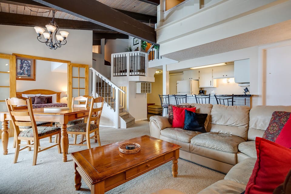 Relax in your spacious open-concept living space with soaring ceilings, exposed beams, and cozy seating perfect for gathering with loved ones.