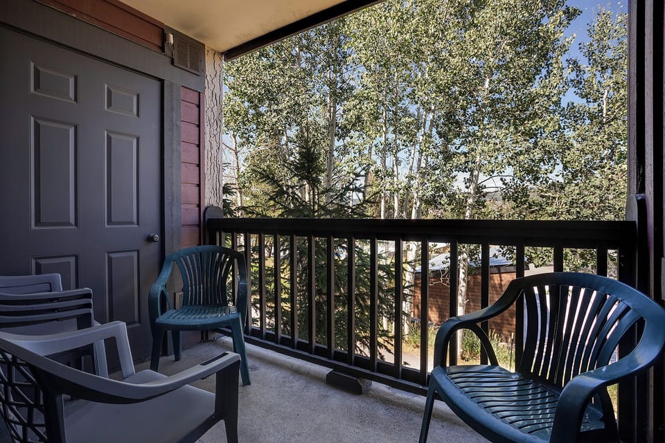 Step onto your private balcony where comfortable seating awaits amidst peaceful treetop views, perfect for morning coffee or evening relaxation.