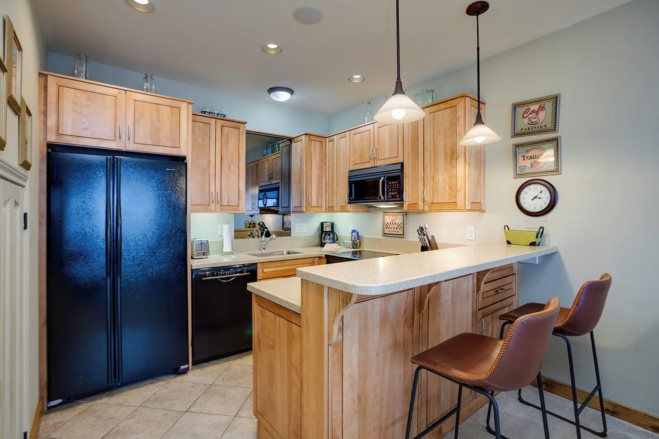 Your fully equipped kitchen features warm wood cabinetry, granite counters, and a breakfast bar perfect for casual dining.