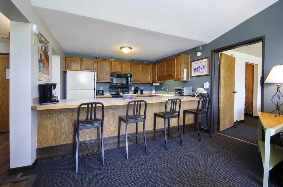 Your spacious kitchen features a large breakfast bar with four stools, perfect for morning coffee or casual meals together.
