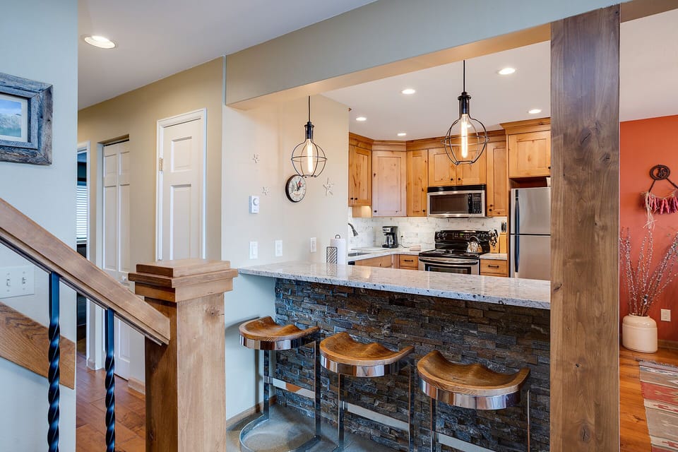 Your open kitchen features warm wood cabinetry, granite counters, and a cozy breakfast bar where you'll love gathering.
