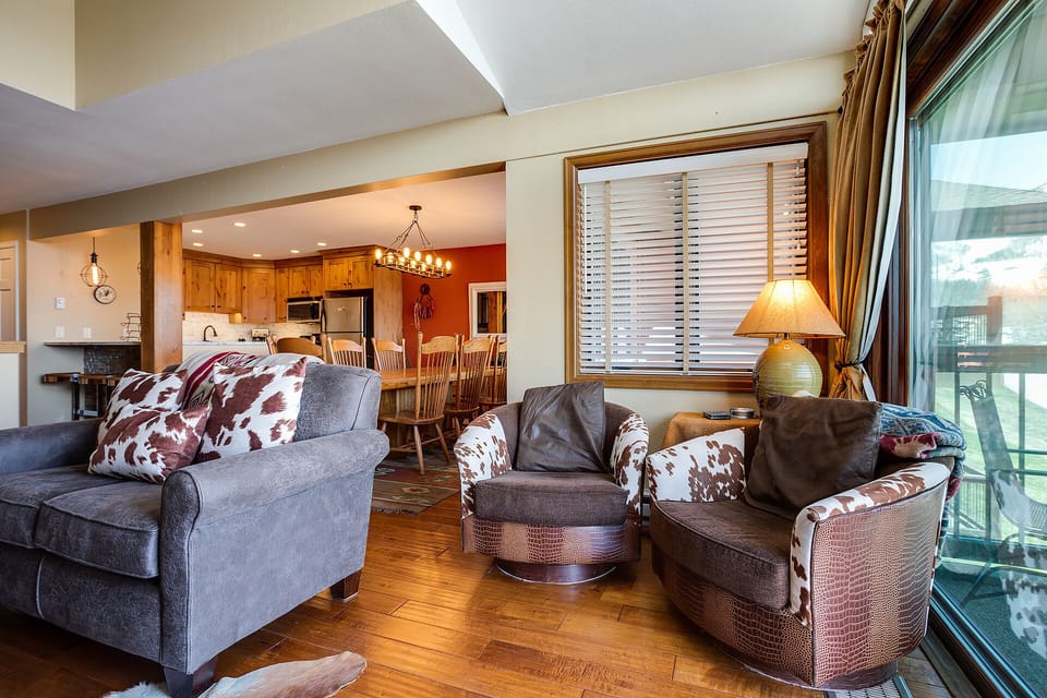 Unwind in your spacious living room with cowhide accent pillows, where rustic charm meets mountain elegance.