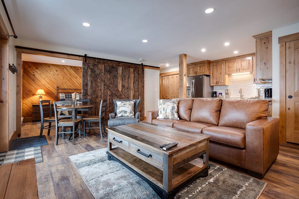 Sink into plush leather seating in your rustic-chic living space, where barn doors and warm wood create the perfect mountain retreat atmosphere.