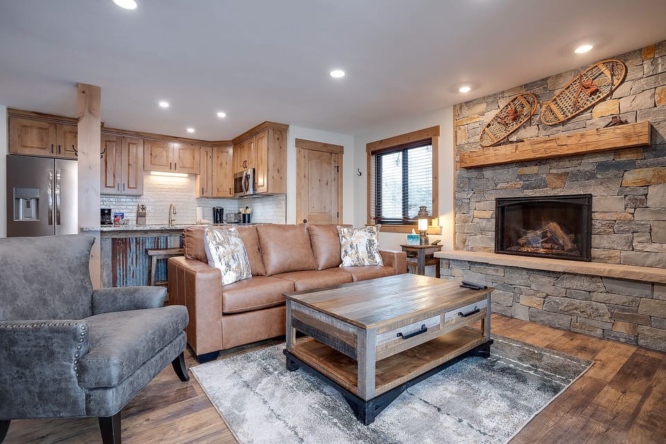 Cozy up by your stone fireplace while enjoying the open-concept living space with rustic charm and modern comforts.