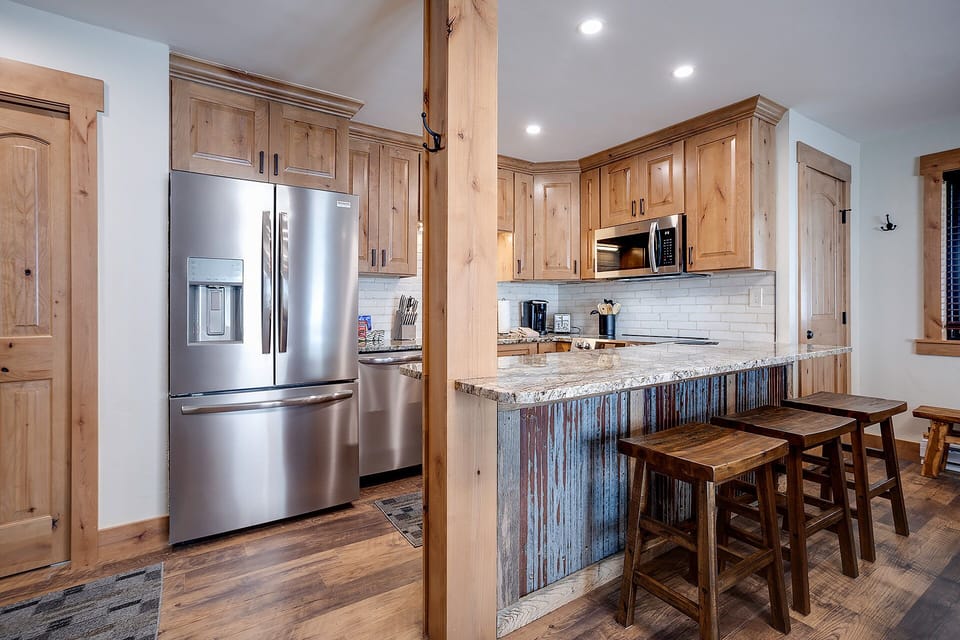Your fully equipped kitchen features warm wood cabinetry, granite counters, and rustic island seating for memorable meal prep together.