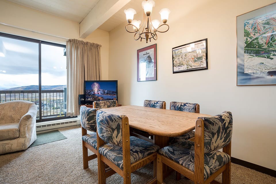 Gather around this cozy dining table while mountain views stretch beyond your window and warm lighting creates the perfect atmosphere for meals.