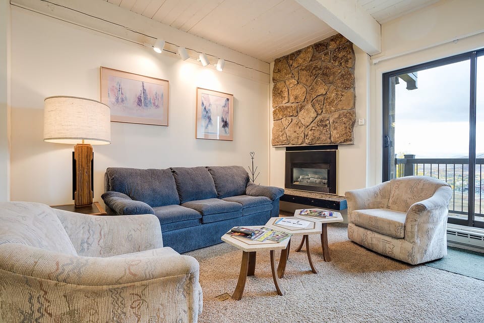 Unwind in your cozy living room, where soft seating surrounds a warm fireplace and natural light streams through large windows.