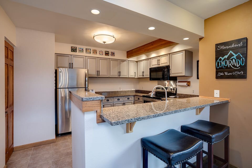 Your fully equipped kitchen features granite counters, stainless appliances, and a breakfast bar perfect for morning coffee or evening wine.