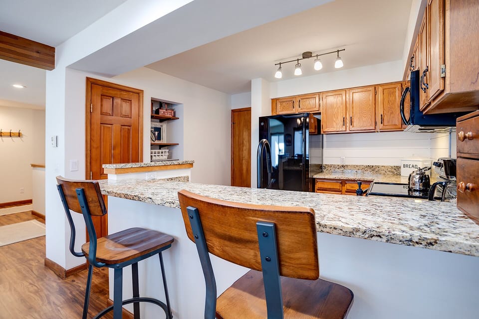 Your fully-equipped kitchen features granite countertops, stainless steel appliances, and a breakfast bar perfect for morning coffee or casual meals together.