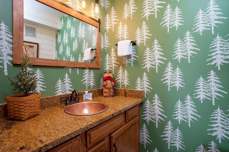 Refresh in your charming woodland-themed bathroom with forest-green walls, copper sink, and cozy cabin details that bring nature indoors for a truly peaceful escape.