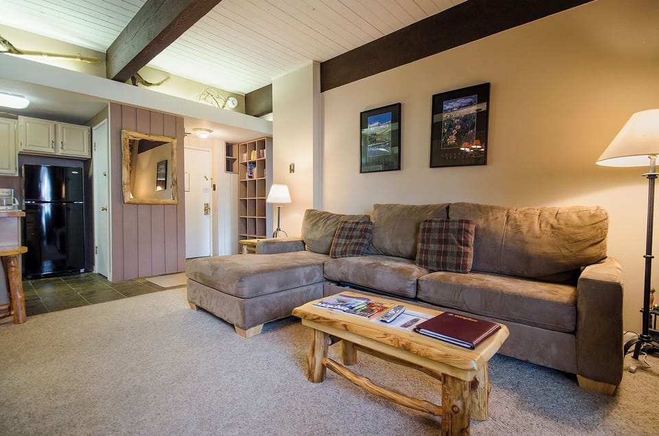 Sink into this plush sectional sofa where you can unwind after mountain adventures, surrounded by rustic charm and cozy lighting.