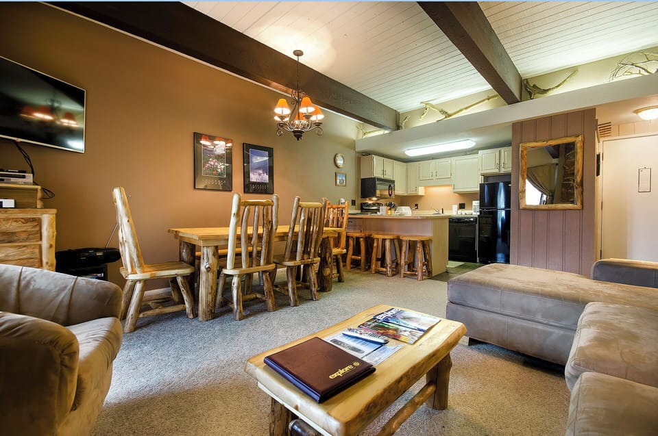 Relax in your cozy mountain retreat with rustic beams, comfortable seating, and a fully equipped kitchen for memorable gatherings.