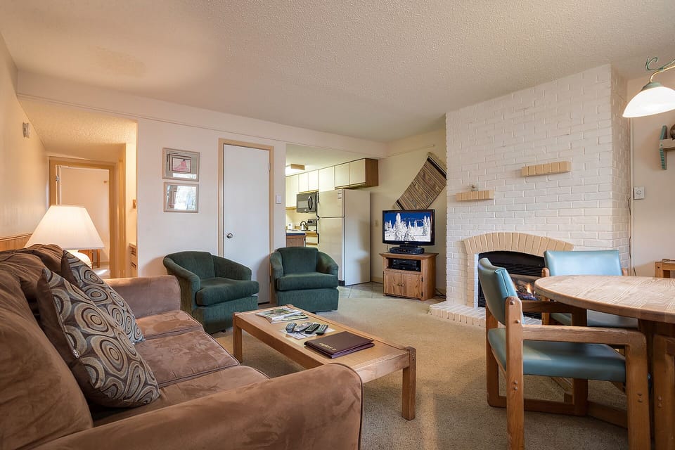 Relax in your spacious living area with plush seating, cozy fireplace, and full kitchen—your perfect mountain retreat awaits.