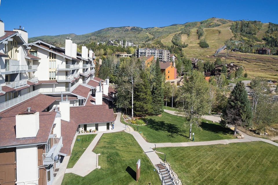 Mountain resort community with ski slopes rising majestically beyond tree-lined neighborhoods and walking paths.