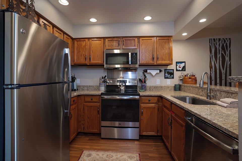 Your fully equipped kitchen features granite counters, stainless appliances, and warm wood cabinets—perfect for preparing memorable meals during your stay.