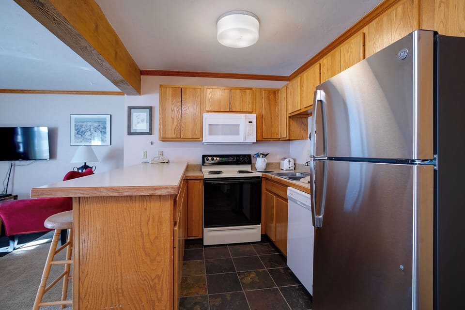 Your fully equipped kitchen features warm wood cabinetry, stainless steel appliances, and a breakfast bar where you can start each morning with coffee.