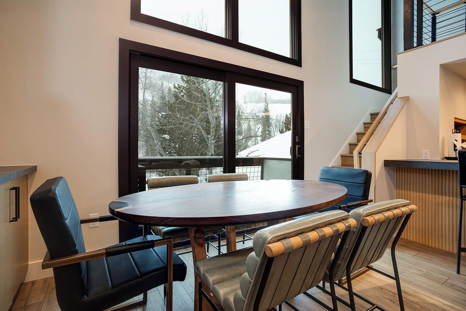 Gather around this stylish dining table where winter mountain views create the perfect backdrop for your memorable meals together.