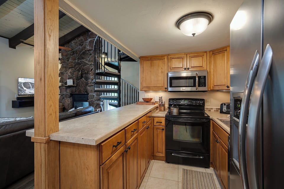 Your fully equipped kitchen features warm wood cabinetry, granite counters, and stainless steel appliances—perfect for preparing memorable meals during your stay.