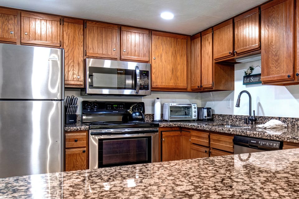 Park Station 133's kitchen has wood cabinets, granite counter tops, and stainless steel appliances.